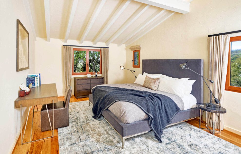 A crisp bed tucks under an angled ceiling