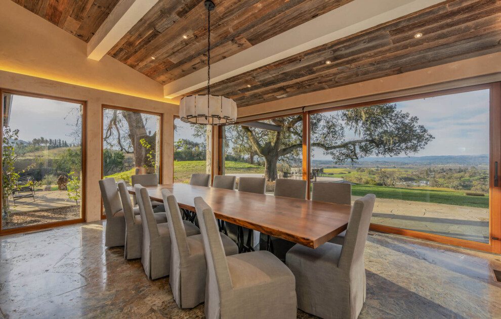A dining room with rustic wooden ceiling and sweeping views